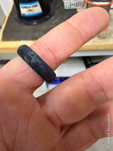 A deep black patina coats the ring